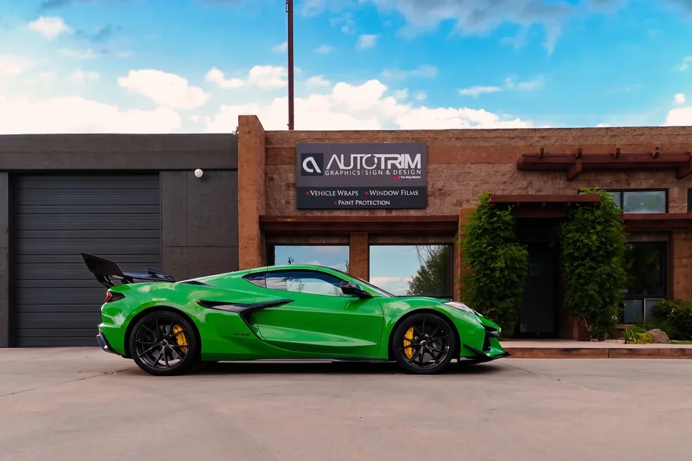 A Corvette in a lime color-change wrap outside the Auto Trim Plus shop
