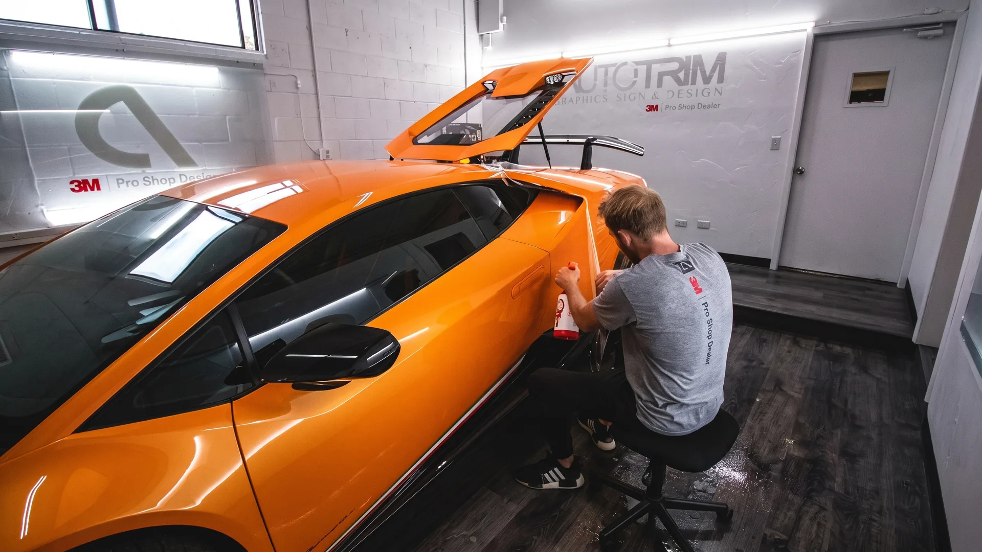 An installer wrapping a Lamborghini at Auto Trim Plus