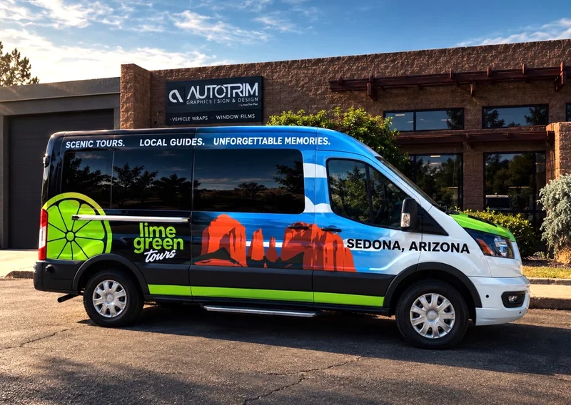 A Lime Green Tours passenger van wrapped with Sedona red rock artwork, outside Auto Trim Plus