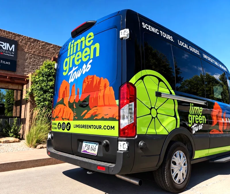 The Lime Green Tours van from the rear quarter, showing the wheel and red rock graphics