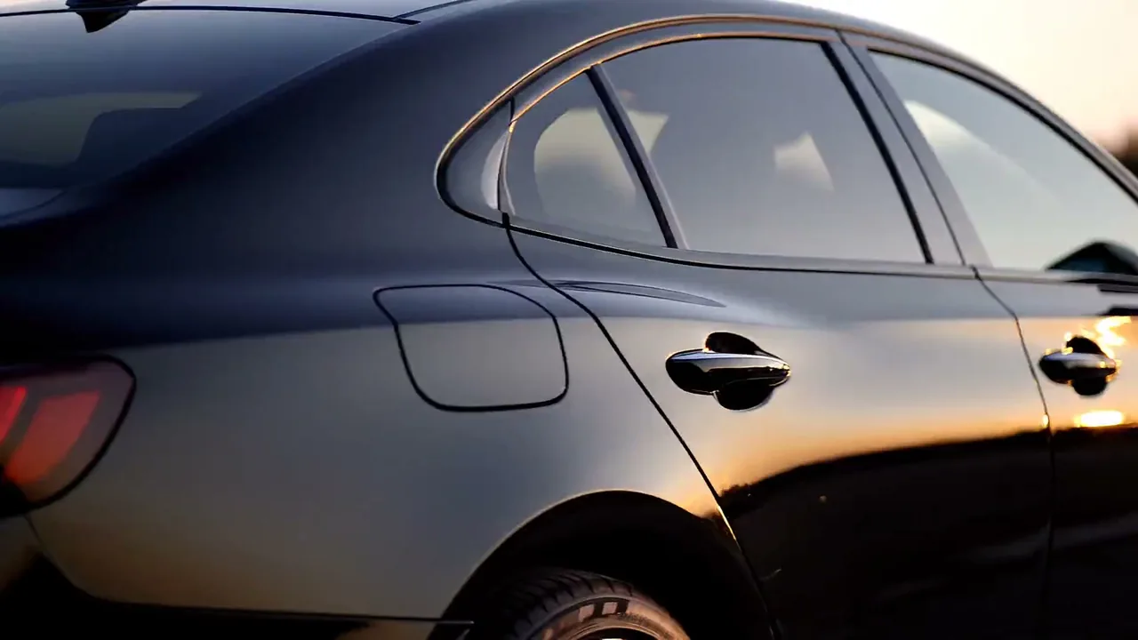 A dark sedan with professionally tinted windows in low sun