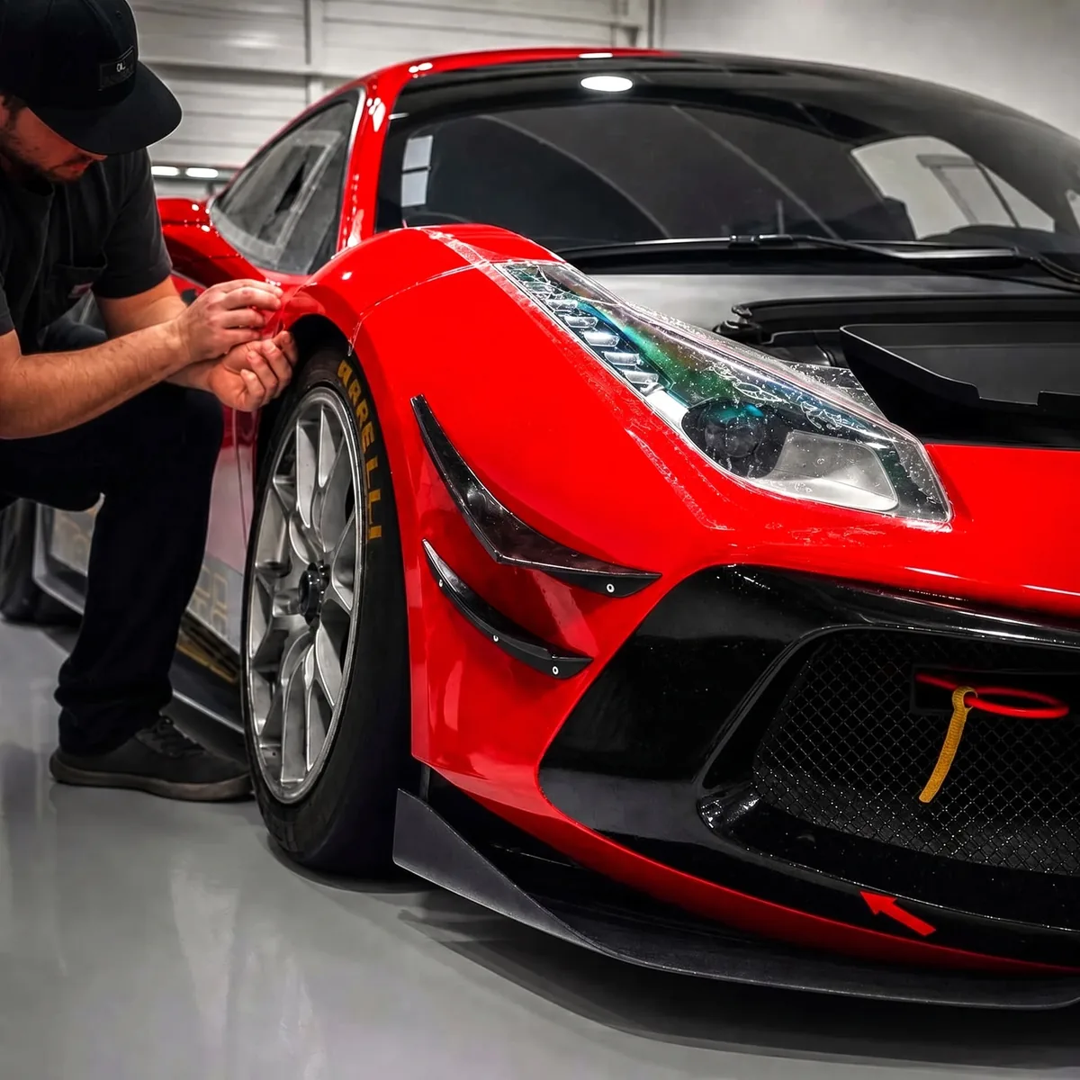 Paint protection film being applied to a red Ferrari